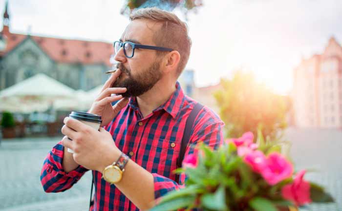 Hombre fumando CBD en la calle